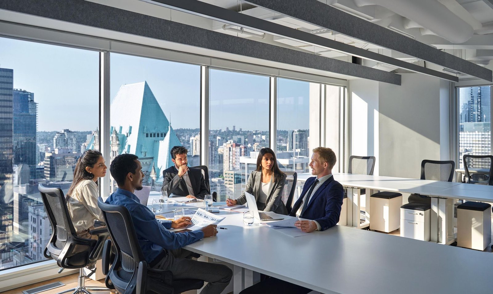Equipo legal en sala de reuniones con vista a la ciudad